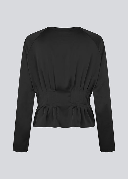 Fitted black top with boxpleats in satin. LivMD shirt has a button closure in front and loose sleeves.