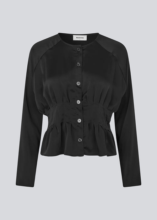 Fitted black top with boxpleats in satin. LivMD shirt has a button closure in front and loose sleeves.