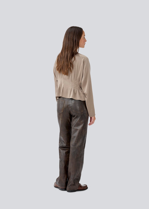 Fitted brown top with boxpleats in satin. LivMD shirt has a button closure in front and loose sleeves.