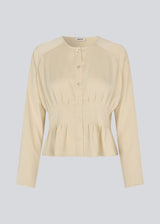 Fitted creme-colored top with boxpleats in satin. LivMD shirt has a button closure in front and loose sleeves.