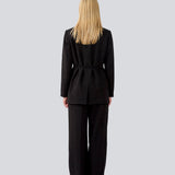 Classic black blazer with an oversize fit and a tieband at the waist. LykkeMD blazer has a satin detail on the collar and a slit in the back. The model is 177 cm and wears a size S/36.