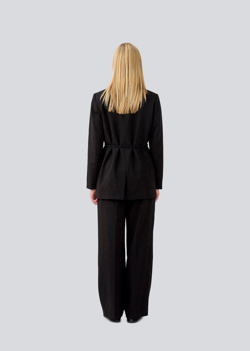 Classic black blazer with an oversize fit and a tieband at the waist. LykkeMD blazer has a satin detail on the collar and a slit in the back. The model is 177 cm and wears a size S/36.