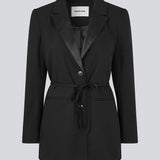 Classic black blazer with an oversize fit and a tieband at the waist. LykkeMD blazer has a satin detail on the collar and a slit in the back. The model is 177 cm and wears a size S/36.