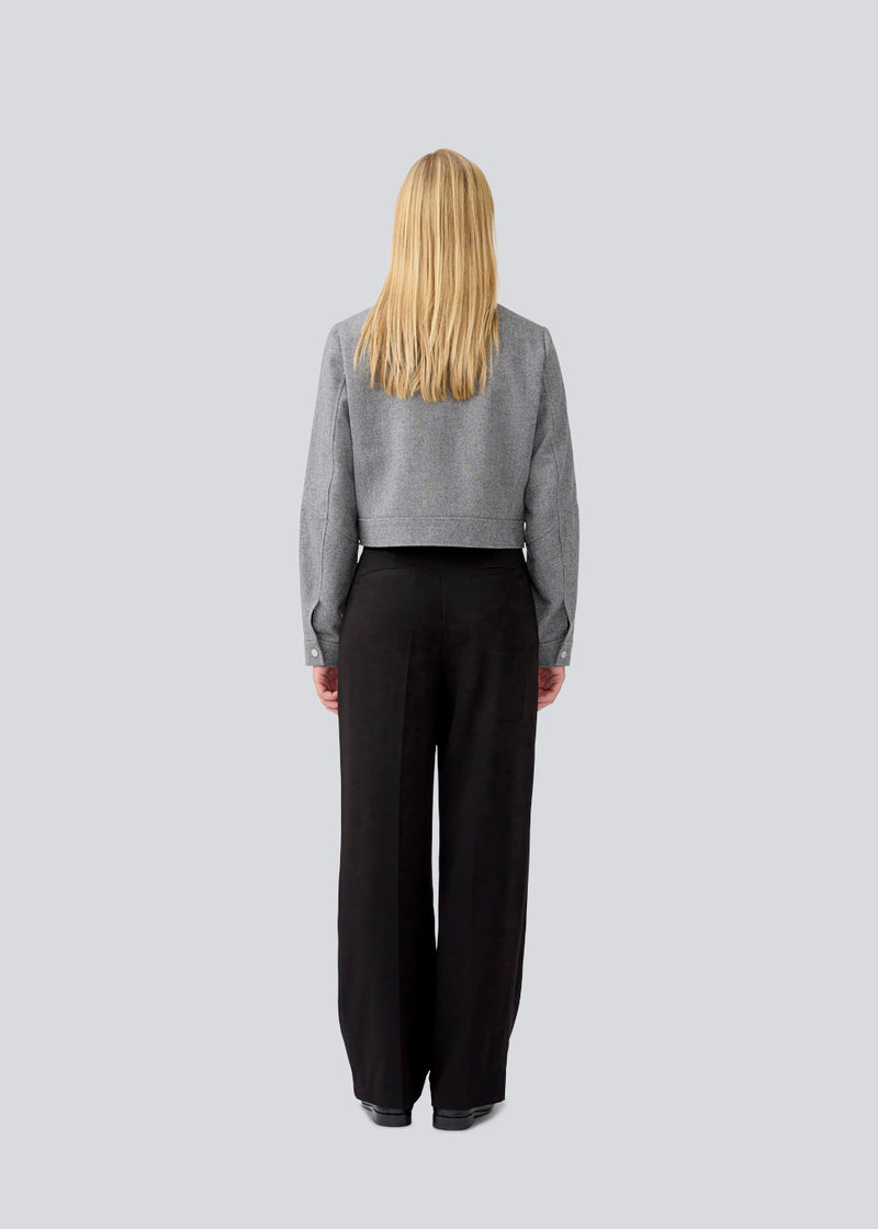 Black suitpants with a tieband at the waist. LykkeMD pants has a zipper, side pockets and paspoil back pockets. The model is 177 cm and wears a size S/36.