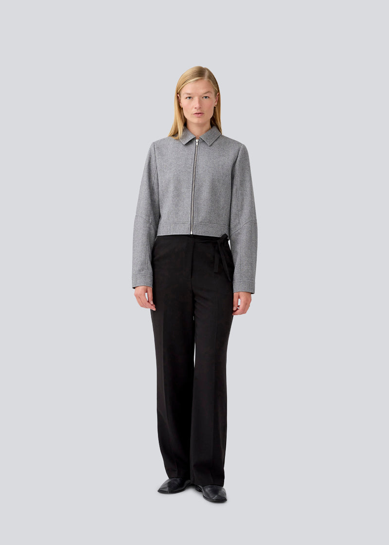 Black suitpants with a tieband at the waist. LykkeMD pants has a zipper, side pockets and paspoil back pockets. The model is 177 cm and wears a size S/36.