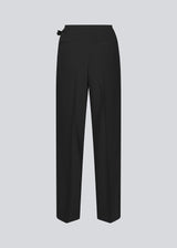 Black suitpants with a tieband at the waist. LykkeMD pants has a zipper, side pockets and paspoil back pockets. The model is 177 cm and wears a size S/36.