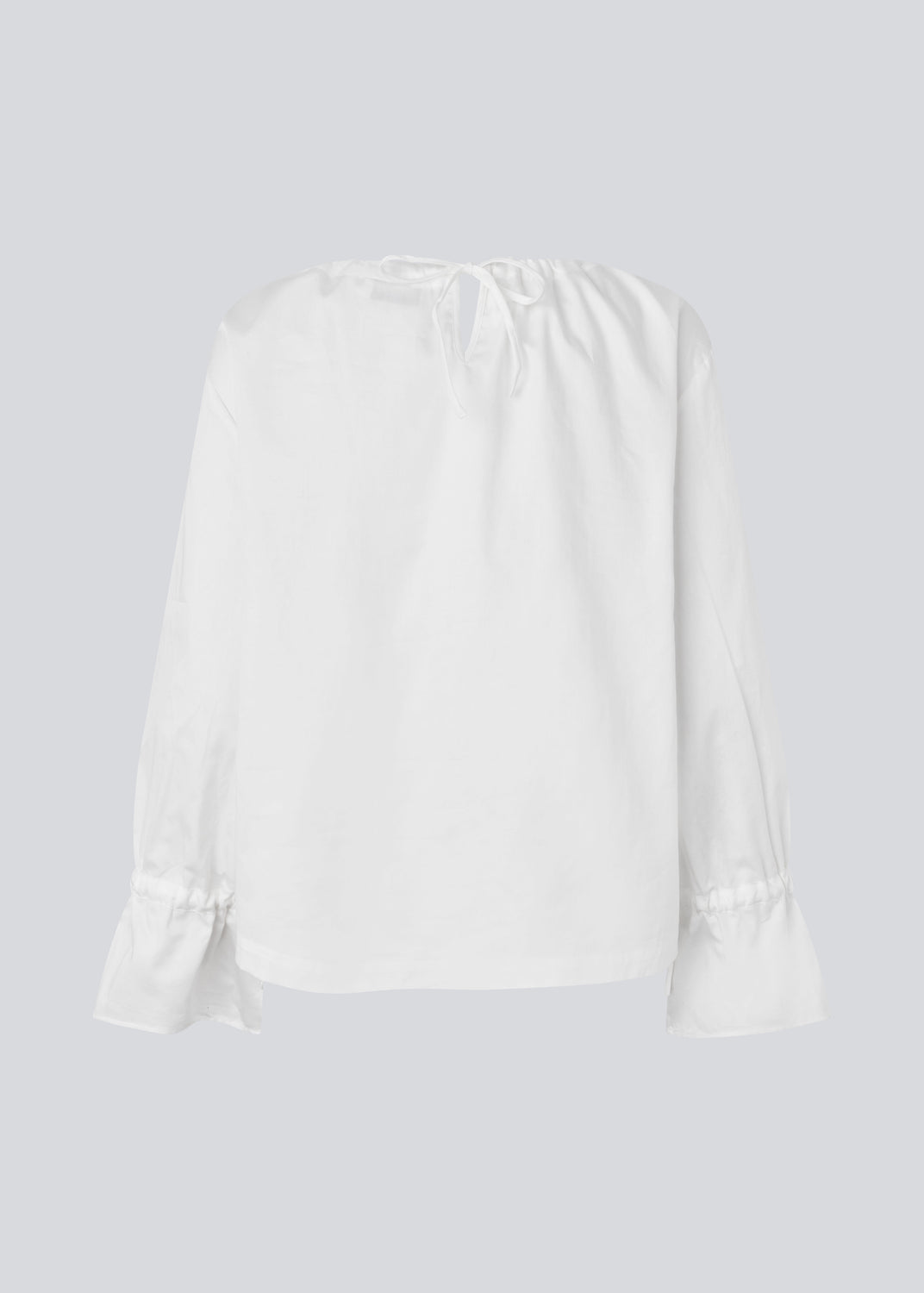 Loose white top with lang sleeves with tiebands. LylaMD top has a round neck with a tieband.
