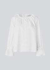 Loose white top with lang sleeves with tiebands. LylaMD top has a round neck with a tieband.