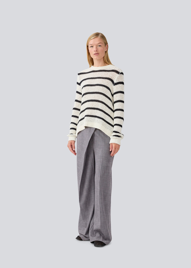 Klassisk strik i hvid med sorte striber i en løs pasform. MaddieMD stripe o-neck har en rund hals og slids i siderne. Modellen er 177 cm og har en str S/36 på.