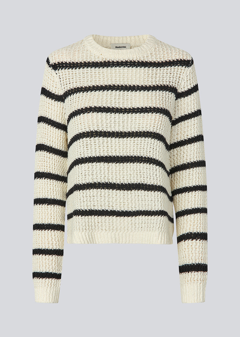 Klassisk strik i hvid med sorte striber i en løs pasform. MaddieMD stripe o-neck har en rund hals og slids i siderne. Modellen er 177 cm og har en str S/36 på.