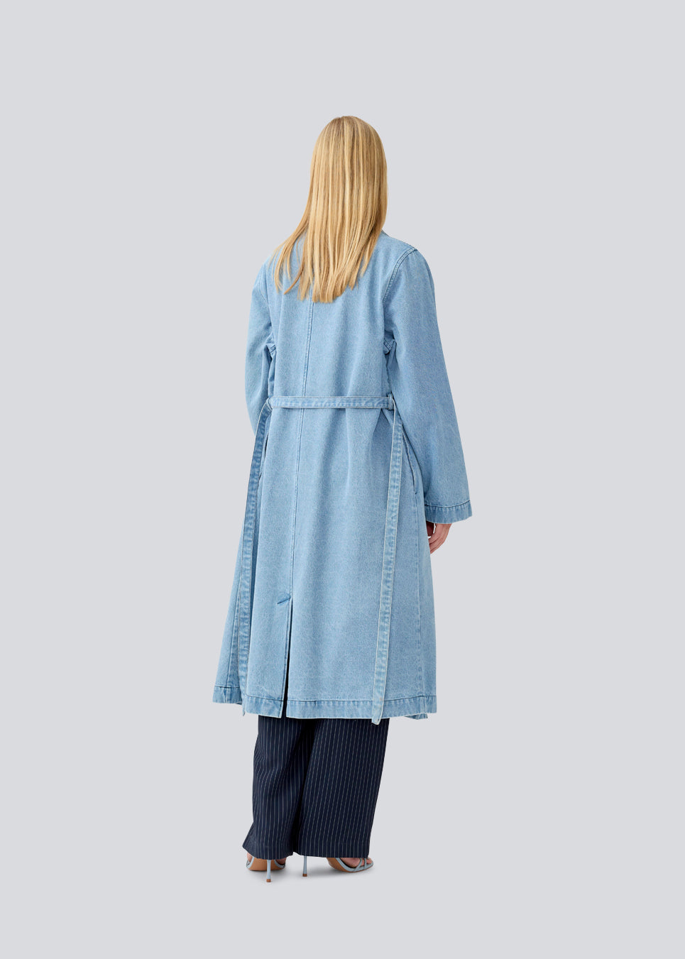 Oversized double-breasted trench coat in denim. MadelineMD denim jacket has dropped shoulders, long wide sleeves and a tieband at the waist. 