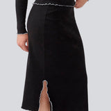 Midi skirt in black with white edges in jersey. MagdaloneMD skirt has slits in the sideseams and babylock edges with an elastic in the waist. The model is 177 cm and wears a size S/36.
