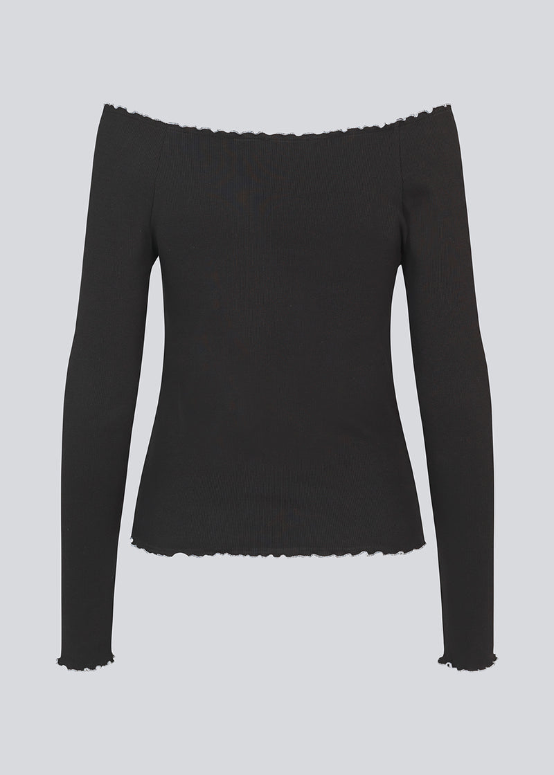 Off-shoulder long sleeve top in black with white edges . MagdaloneMD LS top is fitted and has babylock edges. The model is 177 cm and wears a size S/36.