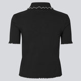 Fitted polo in black with white edges in jersey. MagdaloneMD polo has short sleeves and babylock edges. The model is 177 cm and wears a size S/36