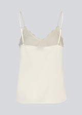 Satin top with a soft drape. TenjaMD top is detailed with lacing on the front and has thin straps.