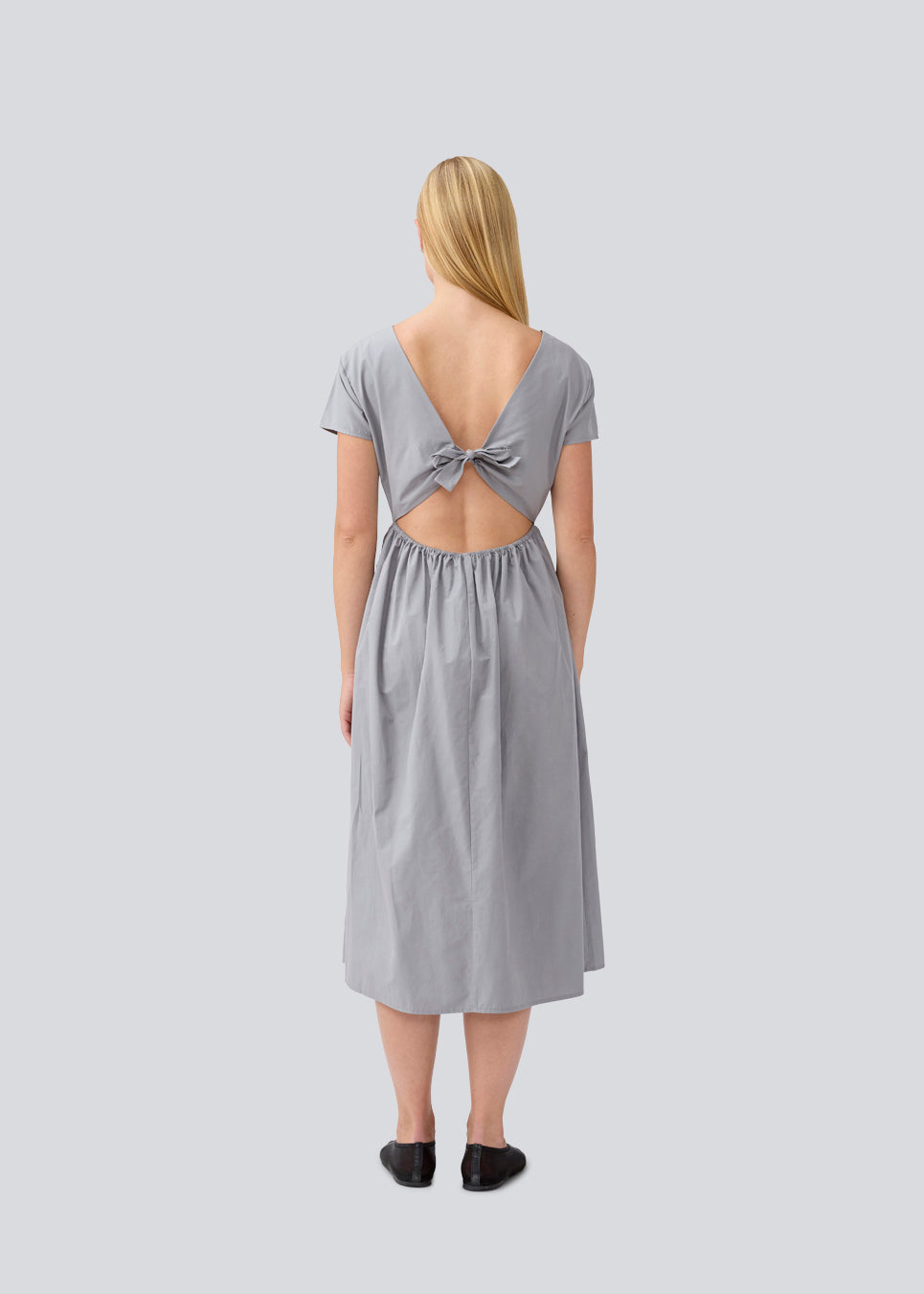 Long dress with short sleeves and a bow detail. MalleMD long dress is fitted with a loose skirt and has an invisible zipper in the side.