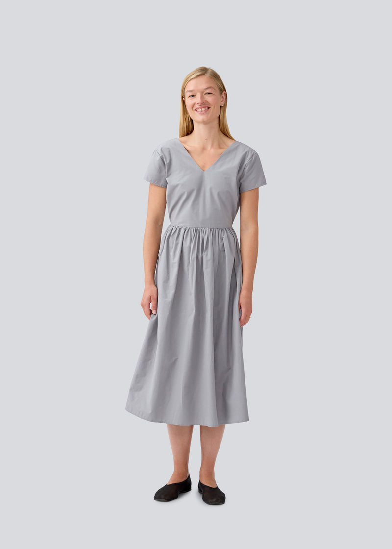 Long dress with short sleeves and a bow detail. MalleMD long dress is fitted with a loose skirt and has an invisible zipper in the side.