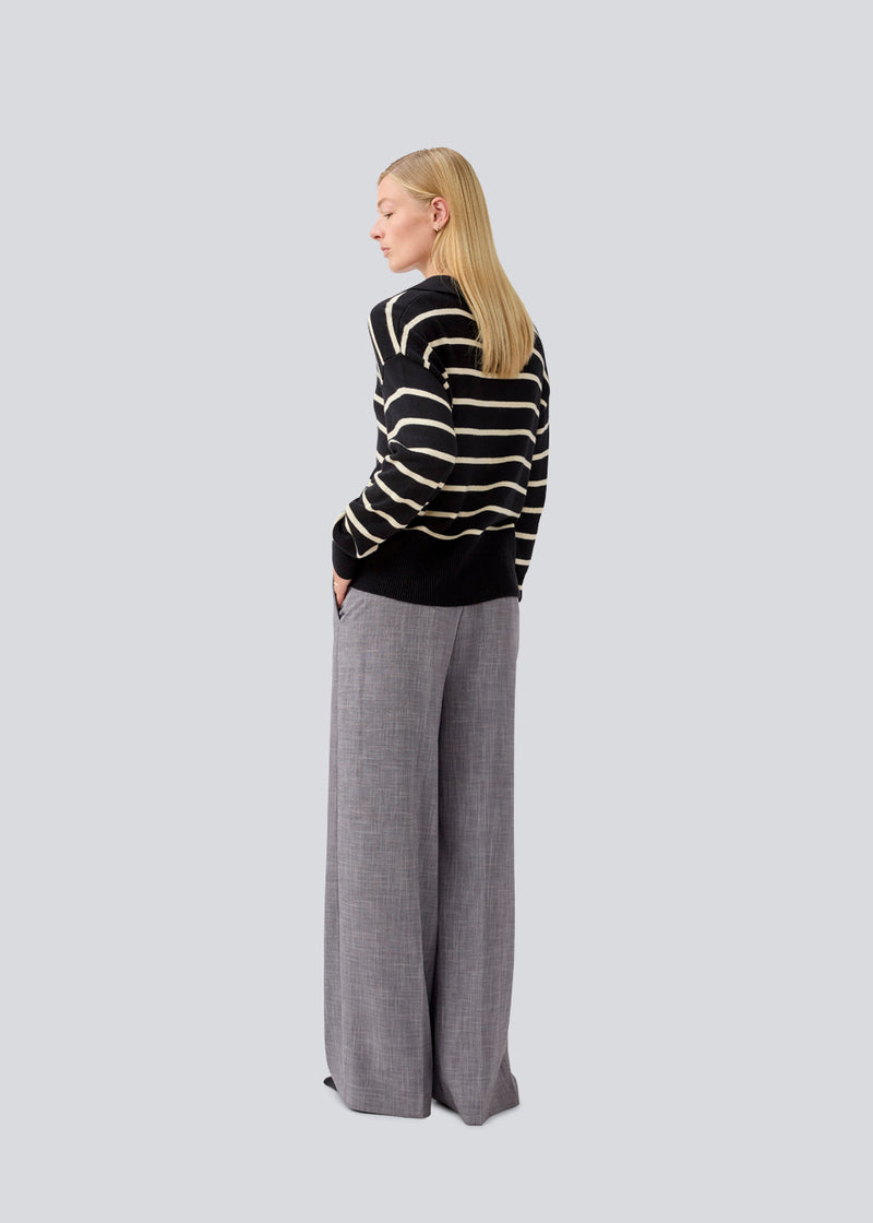 Soft knitted polo in black with white stripes in plain jersey knit. MalvaMD stripe polo has a collar and a button closure in front. The model is 177 cm and wears a size S/36.
The knit is small and slightly cropped.