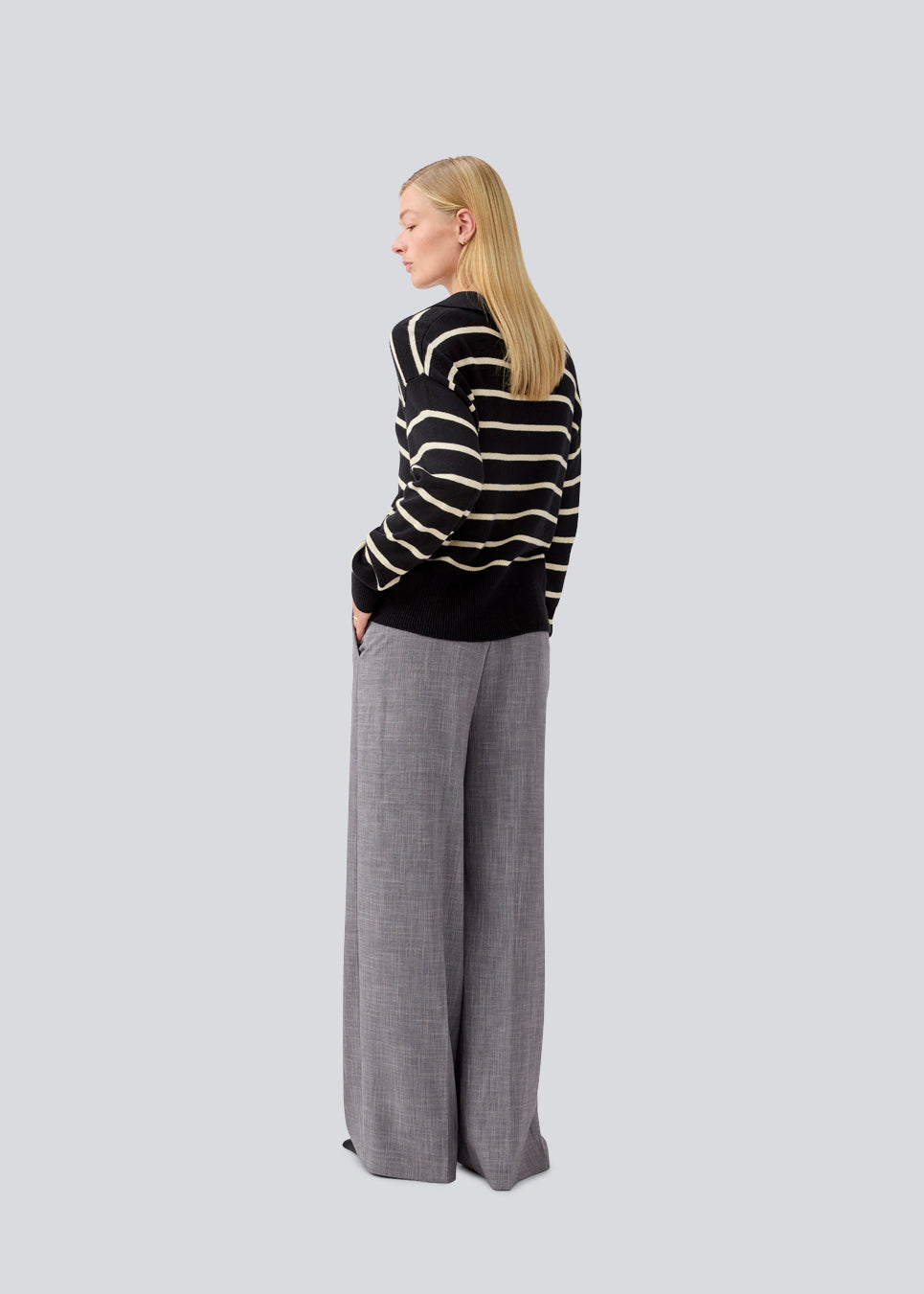 Soft knitted polo in black with white stripes in plain jersey knit. MalvaMD stripe polo has a collar and a button closure in front. The model is 177 cm and wears a size S/36.
The knit is small and slightly cropped.