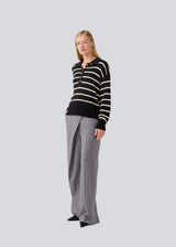 Soft knitted polo in black with white stripes in plain jersey knit. MalvaMD stripe polo has a collar and a button closure in front. The model is 177 cm and wears a size S/36.
The knit is small and slightly cropped.