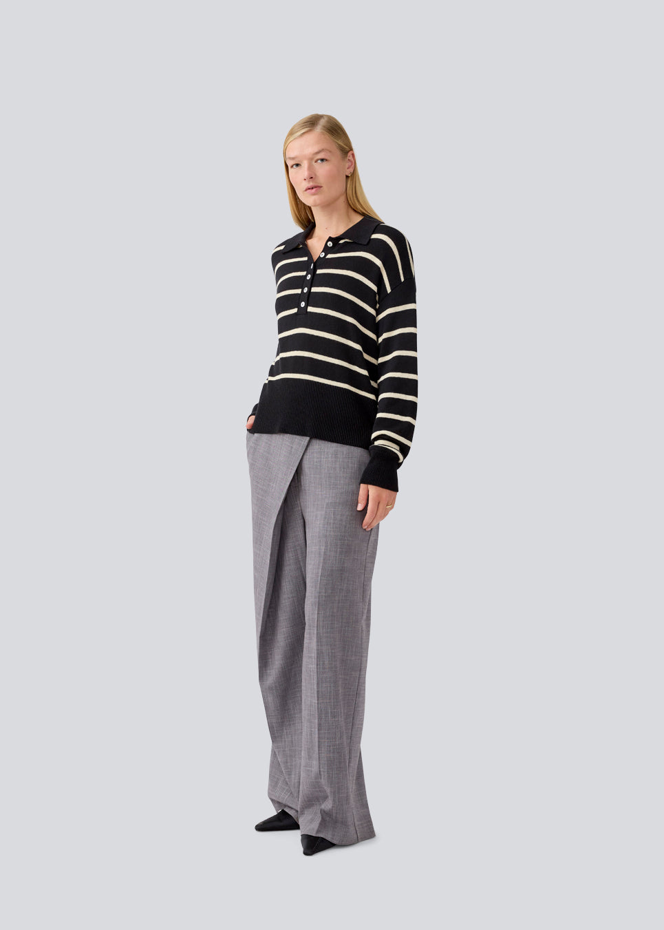 Soft knitted polo in black with white stripes in plain jersey knit. MalvaMD stripe polo has a collar and a button closure in front. The model is 177 cm and wears a size S/36.
The knit is small and slightly cropped.