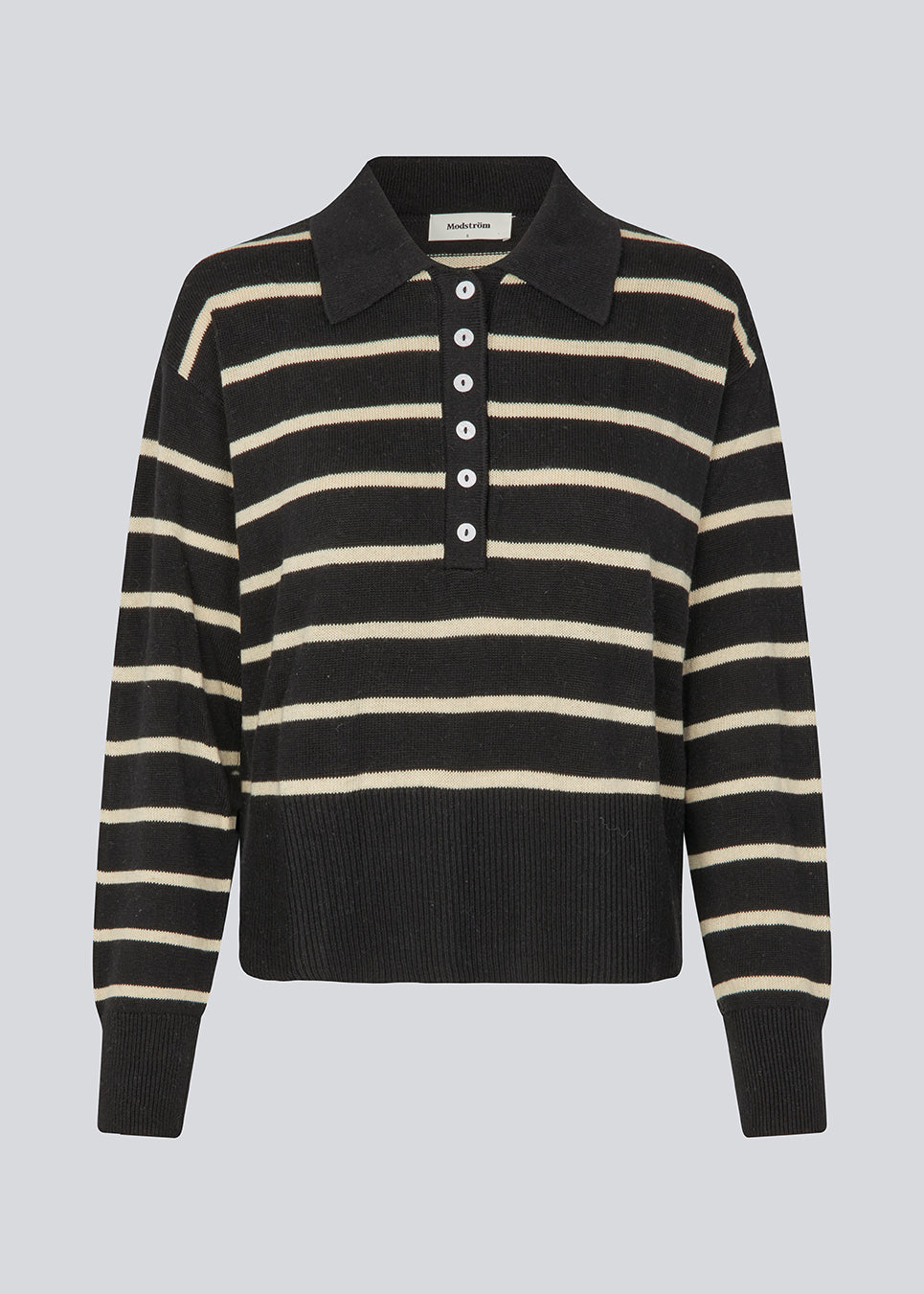 Soft knitted polo in black with white stripes in plain jersey knit. MalvaMD stripe polo has a collar and a button closure in front. The model is 177 cm and wears a size S/36.
The knit is small and slightly cropped.