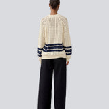 Loose knitted cardigan in beige with navy blue stripes in the button in cable knit. MetteMD cardigan is slightly see-through and has loose sleeves and a button closure. The models are 177 cm and wear a size S/36.&nbsp;

