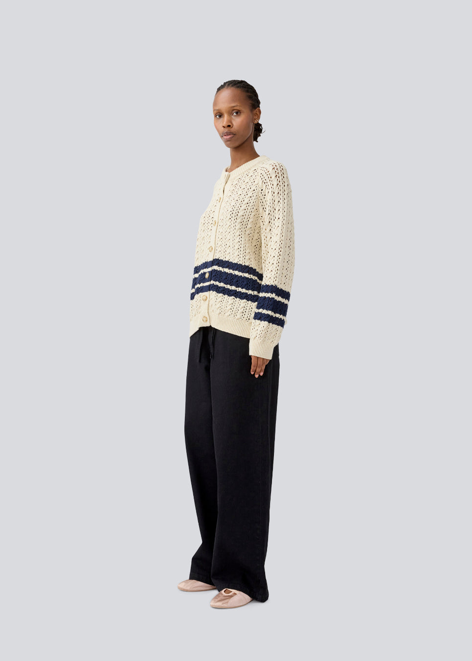 Loose knitted cardigan in beige with navy blue stripes in the button in cable knit. MetteMD cardigan is slightly see-through and has loose sleeves and a button closure. The models are 177 cm and wear a size S/36.&nbsp;
