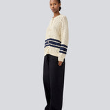 Loose knitted cardigan in beige with navy blue stripes in the button in cable knit. MetteMD cardigan is slightly see-through and has loose sleeves and a button closure. The models are 177 cm and wear a size S/36.&nbsp;
