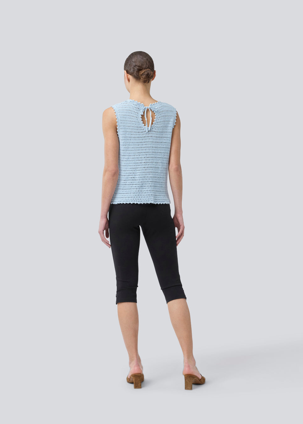 Crochet top in light blue without sleeves in organic cotton. MieMD top has detailed trimmings and a deep v-neckline in the back with a tieband closure. The model is 175 cm and wears a size S/36.