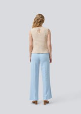 Crochet top in beige without sleeves in organic cotton. MieMD top has detailed trimmings and a deep v-neckline in the back with a tieband closure. The model is 175 cm and wears a size S/36.