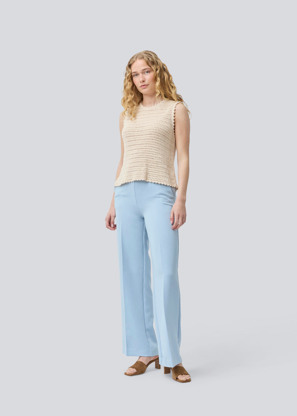 Crochet top in beige without sleeves in organic cotton. MieMD top has detailed trimmings and a deep v-neckline in the back with a tieband closure. The model is 175 cm and wears a size S/36.