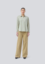 Classic shirt in the color Medium Green Stripe with an opening in the back and bow details. MilleMD stripe shirt has a oversize fit and a cuff with button closure. The model is 177 cm and wears a size S/36.