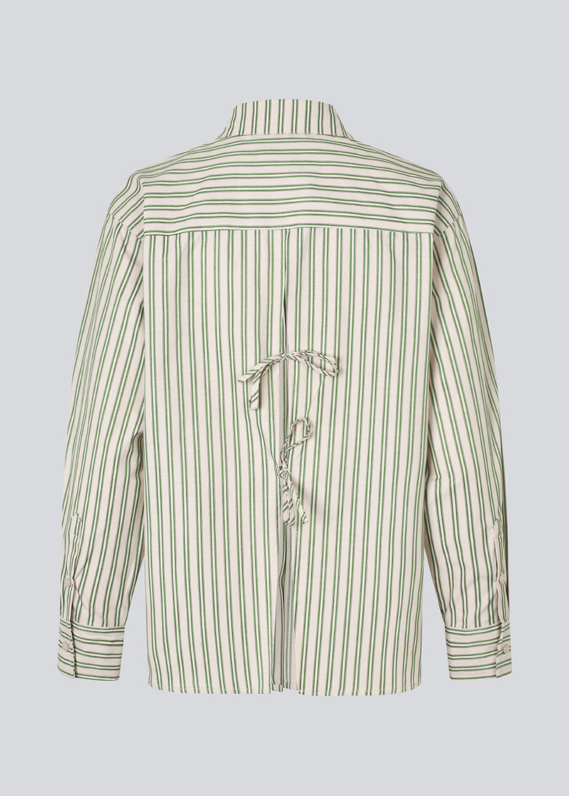 Classic shirt in the color Medium Green Stripe with an opening in the back and bow details. MilleMD stripe shirt has a oversize fit and a cuff with button closure. The model is 177 cm and wears a size S/36.