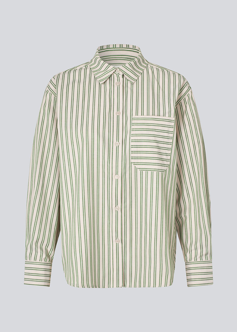 Classic shirt in the color Medium Green Stripe with an opening in the back and bow details. MilleMD stripe shirt has a oversize fit and a cuff with button closure. The model is 177 cm and wears a size S/36.