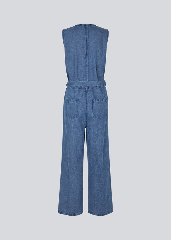 Sleeveless jumpsuit with a tieband in denim. MinniMD jumpsuit has long wide legs, sidepockets and a button closure in front. 