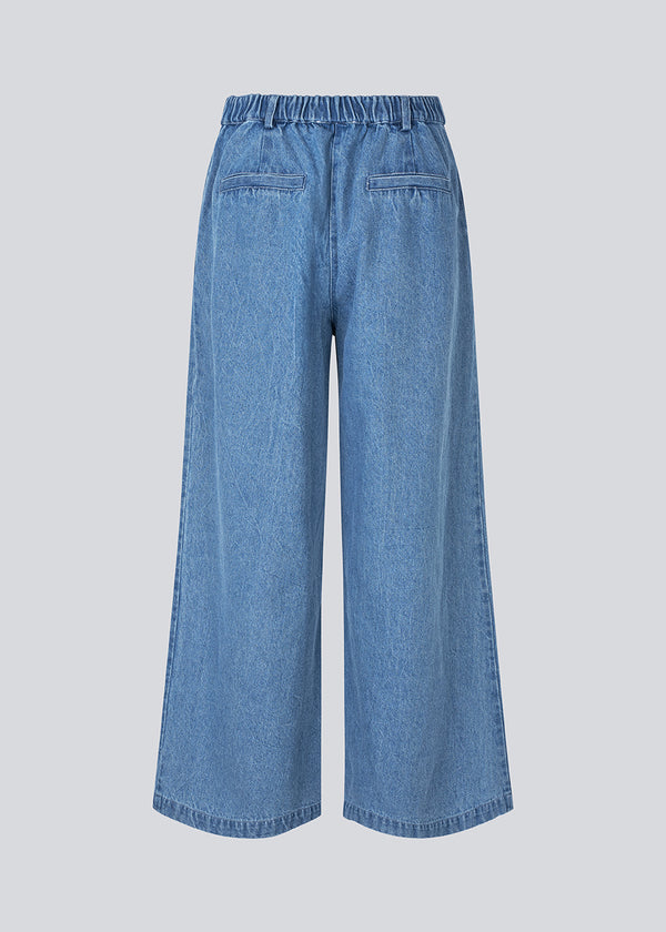 Suit pants in denim with wide legs and pleats at the top. MinniMD pants has a medium-highwaist, zipper, side pockets and paspoil pocketin the back