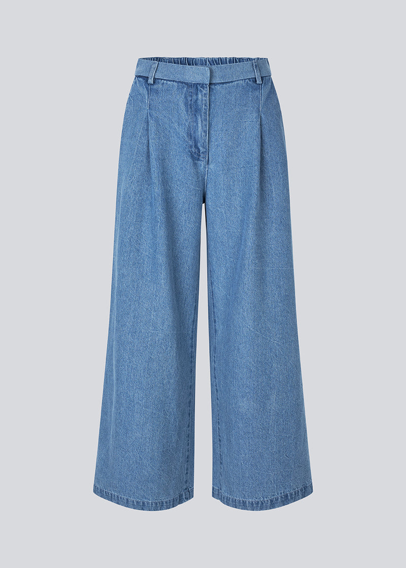 Suit pants in denim with wide legs and pleats at the top. MinniMD pants has a medium-highwaist, zipper, side pockets and paspoil pocketin the back