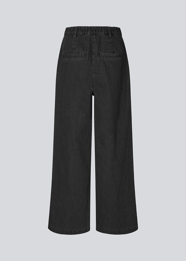 Suit pants in denim with wide legs and pleats at the top. MinniMD pants has a medium-high waist, zipper, side pockets and paspoil pocket in the back.
