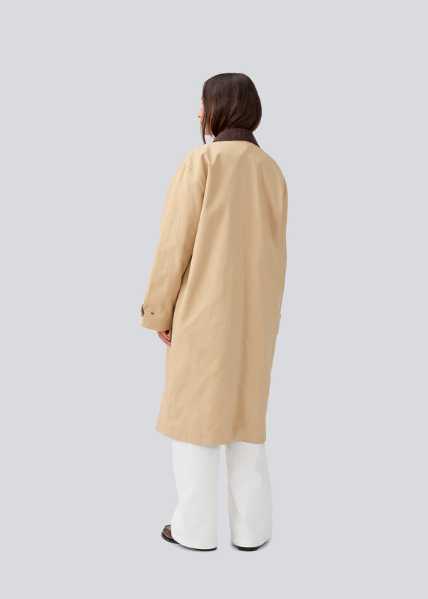 Long jacket with a corduroy collar. MiraMD jacket has a hidden zipper closure in front, tree front pockets and wide sleeves with adjustable straps.