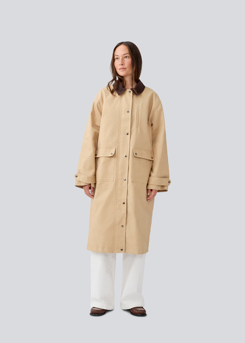 Long jacket with a corduroy collar. MiraMD jacket has a hidden zipper closure in front, tree front pockets and wide sleeves with adjustable straps.