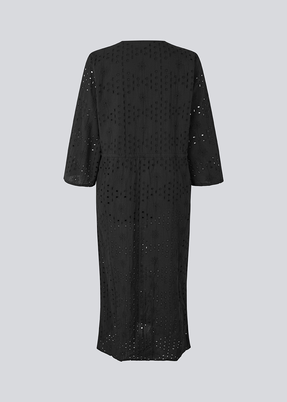 Maxi dress in broderie anglaise. MisoMD dress has a loose fit, v-neck and a tieband at the waist. 