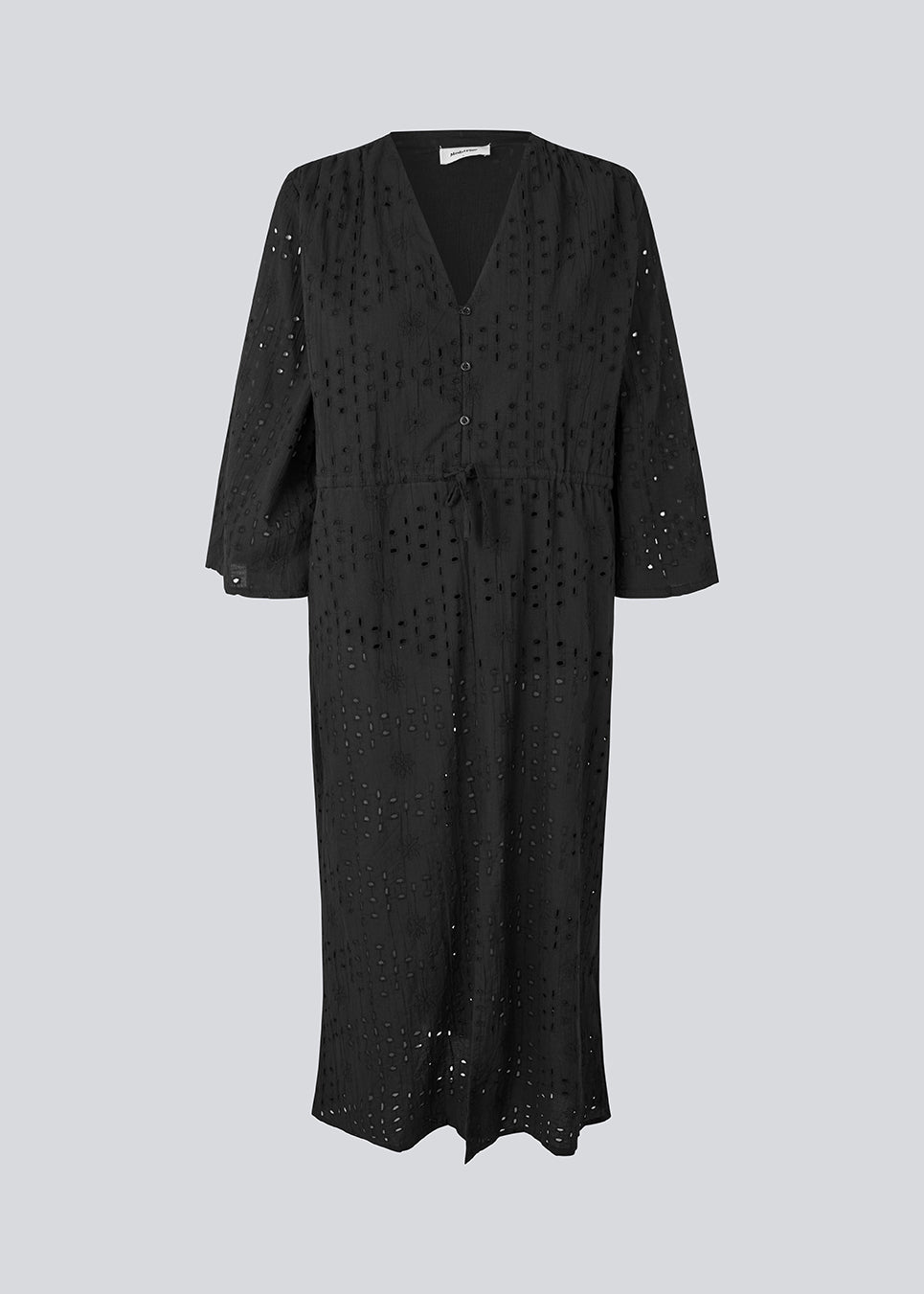 Maxi dress in broderie anglaise. MisoMD dress has a loose fit, v-neck and a tieband at the waist. 