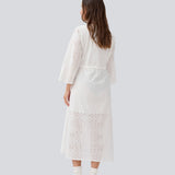 Maxi dress in broderie anglaise. MisoMD dress has a loose fit, v-neck and a tieband at the waist. 