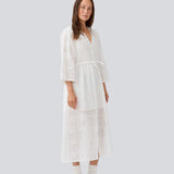 Maxi dress in broderie anglaise. MisoMD dress has a loose fit, v-neck and a tieband at the waist. 