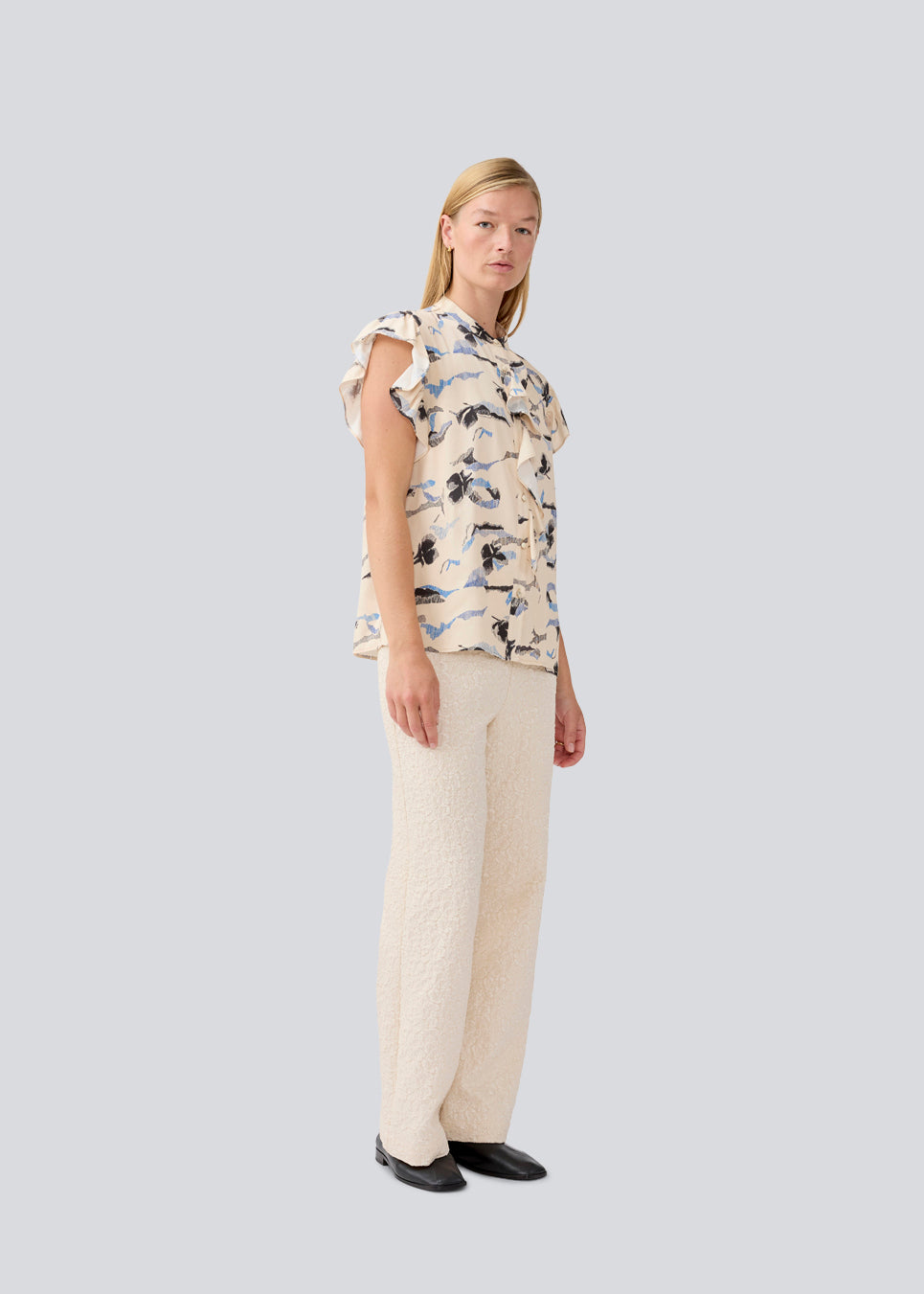 Sleeveless top with frill details. MistMD SS top has a loose fit and a button closure with frill details in front. 