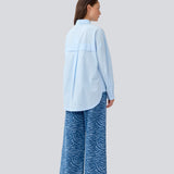 Blue classic shirt with an oversize fit. MyraMD shirt has a hidden buttonclosure in front and slits in the sides. The model is 177 cm and wears a size S/36.