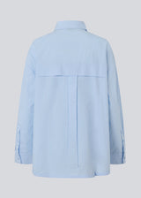 Blue classic shirt with an oversize fit. MyraMD shirt has a hidden buttonclosure in front and slits in the sides. The model is 177 cm and wears a size S/36.