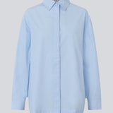 Blue classic shirt with an oversize fit. MyraMD shirt has a hidden buttonclosure in front and slits in the sides. The model is 177 cm and wears a size S/36.