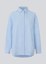 Blue classic shirt with an oversize fit. MyraMD shirt has a hidden buttonclosure in front and slits in the sides. The model is 177 cm and wears a size S/36.